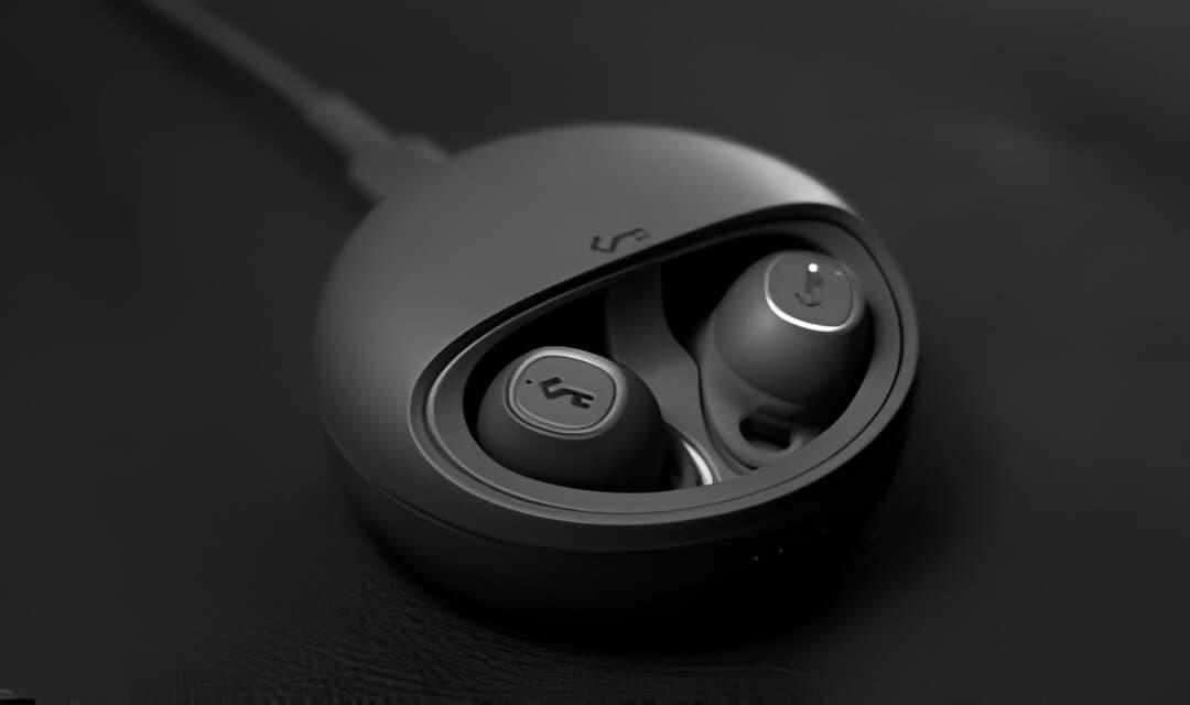 A pair of wireless earbuds in a charging case. The earbuds are black and have a glossy finish. They appear to have a touch sensor on the outside. The charging case is also black and has a rounded rectangular shape. There is a small LED light on the front of the case, which may indicate the charging status of the earbuds.