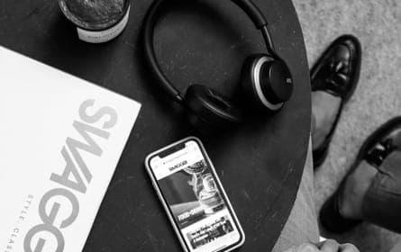 XX99 Mark II headphones resting on a table beside a phone and magazine, symbolizing a moment of relaxation and personal time.
