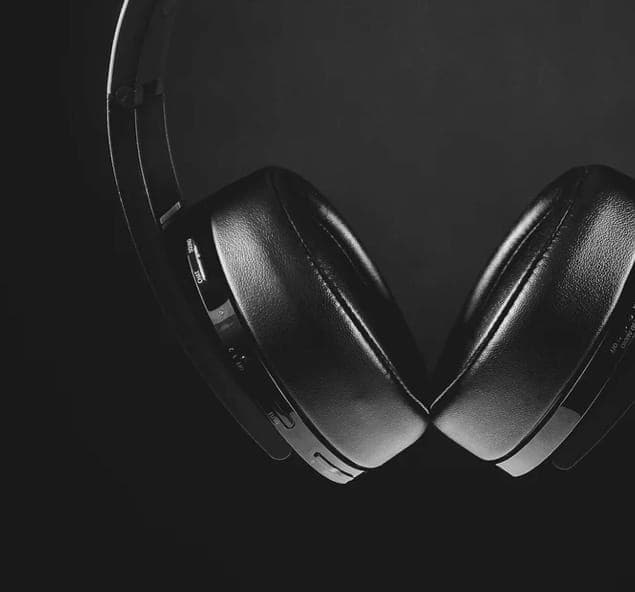 Close up of black XX99 Mark II headphones on a black background. The headphones have a sleek, minimalist design with ear tips and a glossy finish.